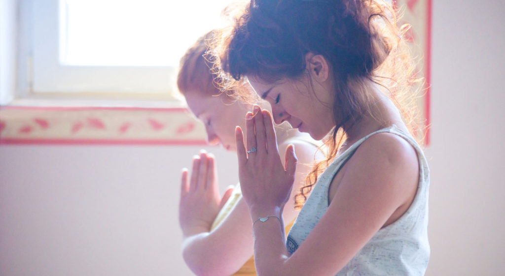 Women in yoga class closeup hands in namaste