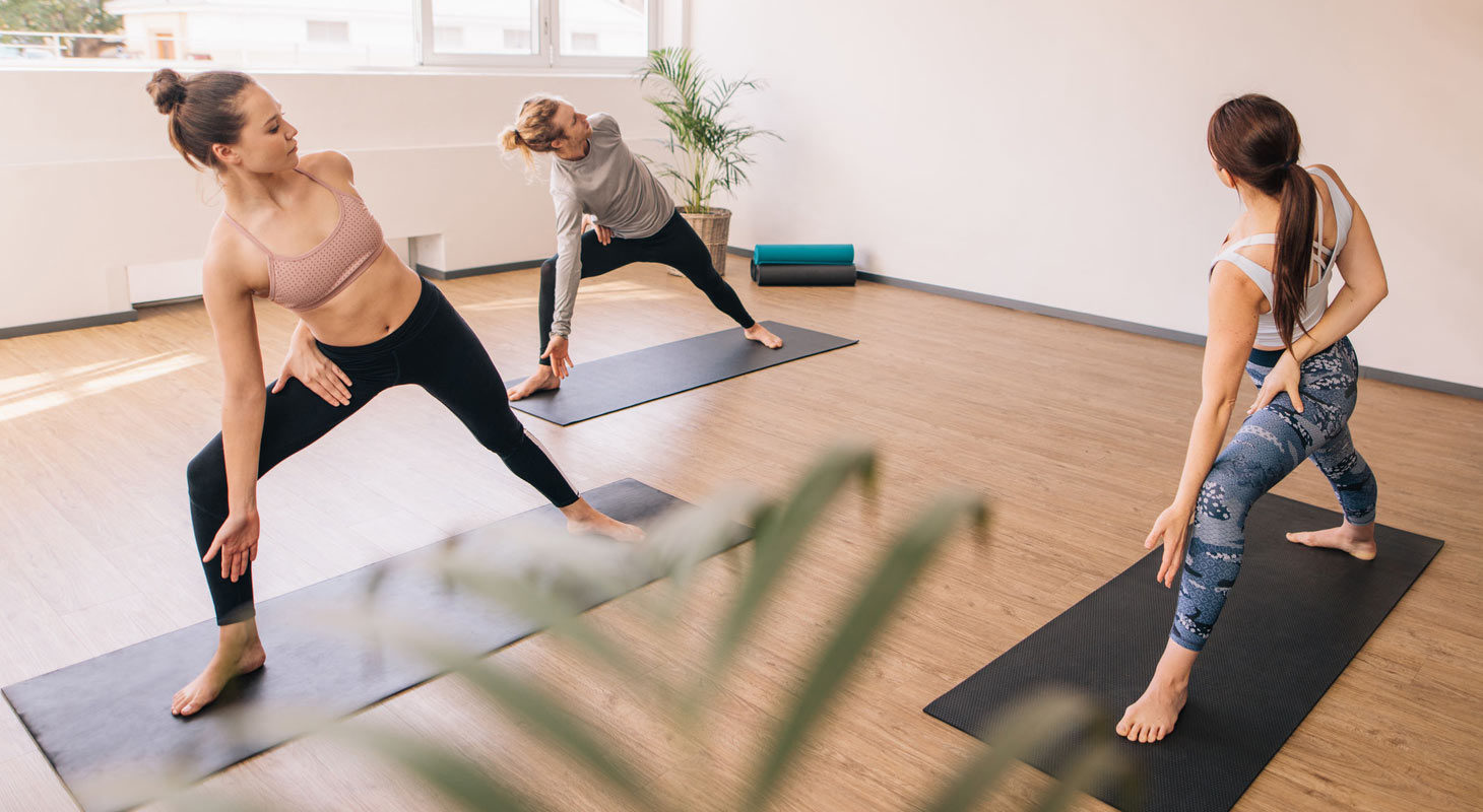 Trois femmes pratiquant le yoga en classe