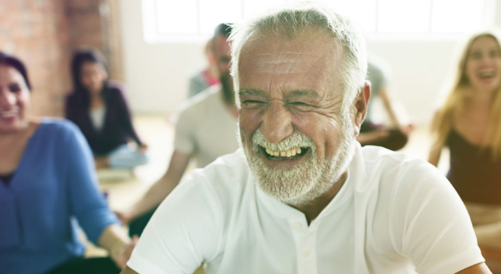 Homme qui rigole dans un cours de yoga du rire