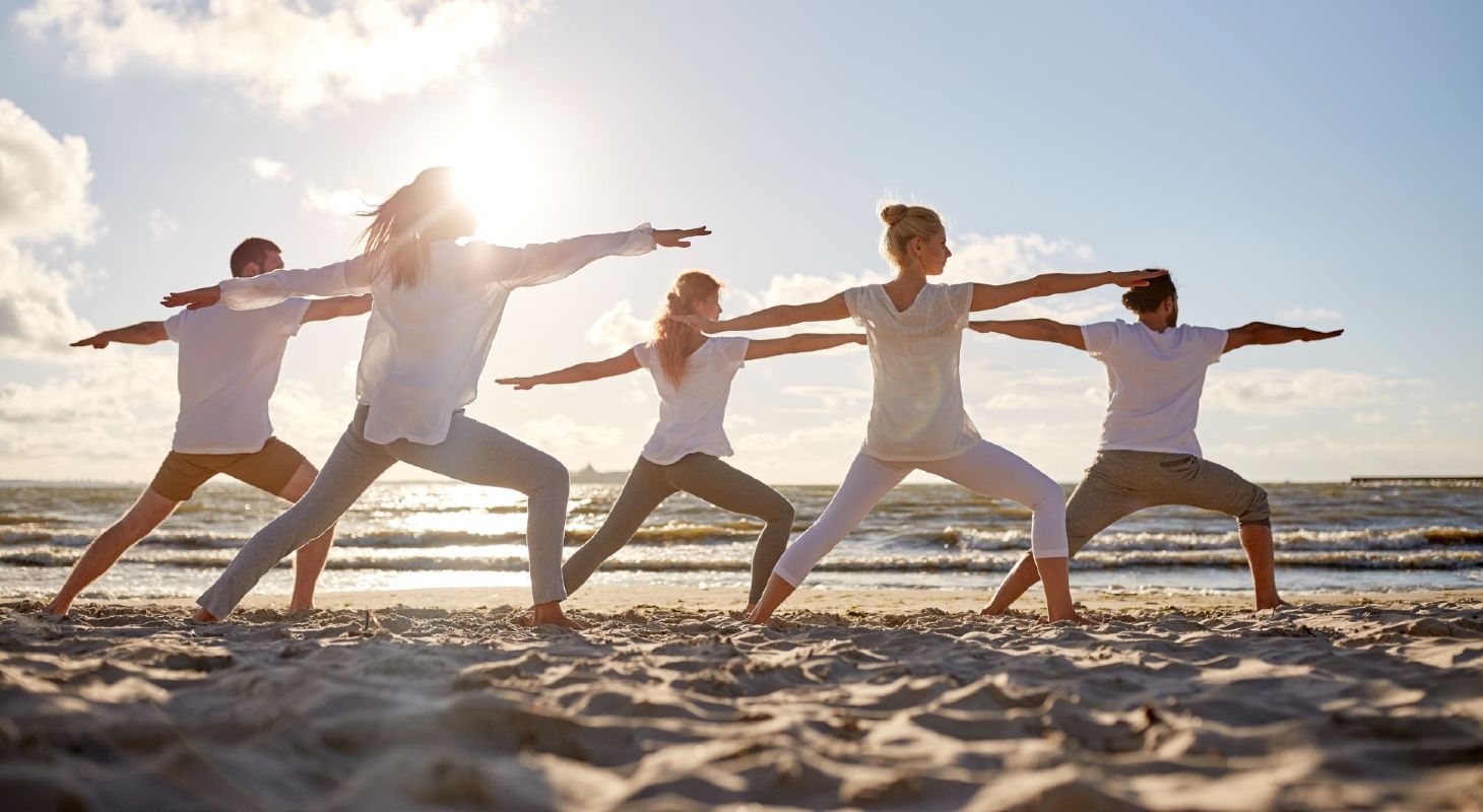 Groupe de personnes pratiquant le yoga sur la plage